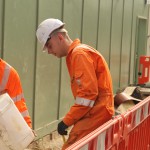 Electical Engineer Lad Wearing Portwest Bizflame Orange Boilersuit 1 Engineer lad replacing street paving that was removed to install a new electricity supply