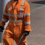 Road workers wearing orange hi-vis boilersuits and coveralls