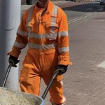 Road workers wearing orange hi-vis boilersuits and coveralls