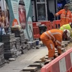Road workers wearing orange hi-vis boilersuits and coveralls