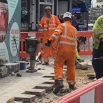 Road workers wearing orange hi-vis boilersuits and coveralls