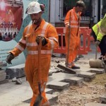 Road workers wearing orange hi-vis boilersuits and coveralls