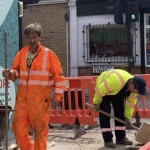 Road workers wearing orange hi-vis boilersuits and coveralls