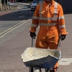 Road workers wearing orange hi-vis boilersuits and coveralls