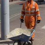 Road workers wearing orange hi-vis boilersuits and coveralls